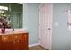 Bathroom featuring a wood vanity with a sink and a large mirror at 24308 Belle Mede Dr, Leesburg, FL 34748