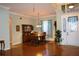 Formal dining room with wood floors, a china cabinet, and a view of the front entryway with a decorative door at 24308 Belle Mede Dr, Leesburg, FL 34748