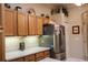 Kitchen with stainless steel refrigerator and wood cabinets at 24308 Belle Mede Dr, Leesburg, FL 34748