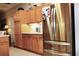 Kitchen featuring stainless steel refrigerator, oak cabinets, and tile flooring at 24308 Belle Mede Dr, Leesburg, FL 34748