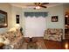 Bright living room with hardwood floors, floral sofas, and a ceiling fan at 24308 Belle Mede Dr, Leesburg, FL 34748