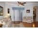 Bright living room with hardwood floors, floral sofas, and a ceiling fan at 24308 Belle Mede Dr, Leesburg, FL 34748