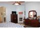 Comfortable main bedroom with TV, dresser, and access to the en-suite bathroom at 24308 Belle Mede Dr, Leesburg, FL 34748