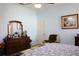 Serene main bedroom featuring light blue walls, ample dresser space, and a comfortable chair at 24308 Belle Mede Dr, Leesburg, FL 34748