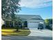 House exterior showcasing a two-car garage and manicured lawn at 2458 Dunkirk Trl, The Villages, FL 32162