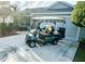 Green golf cart parked in front of a home at 2458 Dunkirk Trl, The Villages, FL 32162