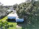 An aerial view of a single-story home with a metal roof and large trees at 25143 Barrow Hl, Leesburg, FL 34748