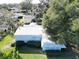 Aerial view of a light blue home with a metal roof and green lawn at 25143 Barrow Hl, Leesburg, FL 34748