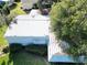 Aerial view of a single-story home with metal roof, surrounded by lush landscaping at 25143 Barrow Hl, Leesburg, FL 34748