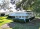 Single-story home with awning windows, surrounded by trees and a lawn at 25143 Barrow Hl, Leesburg, FL 34748