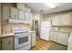 Kitchen with white appliances, wood flooring, and ample cabinet space at 25143 Barrow Hl, Leesburg, FL 34748