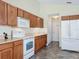 Kitchen boasts oak cabinets, white appliances and tiled floors at 25220 Waterbridge Ct, Leesburg, FL 34748