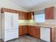 Corner kitchen with oak cabinets, white appliances and tiled floor at 25220 Waterbridge Ct, Leesburg, FL 34748