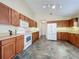 Bright kitchen with oak cabinets and white appliances, tiled floor at 25220 Waterbridge Ct, Leesburg, FL 34748