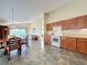 Bright kitchen with wood cabinets, tile floor, and view into adjoining living area at 25220 Waterbridge Ct, Leesburg, FL 34748