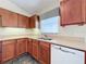 Kitchen features a corner sink, oak cabinets, and a dishwasher at 25220 Waterbridge Ct, Leesburg, FL 34748