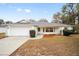 Single-story house with a white exterior, gray roof, and landscaped lawn at 26 Pecan Pass Run, Ocala, FL 34472