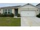 House exterior featuring a two-car garage and landscaping at 29320 Armoyan Blvd, Leesburg, FL 34748