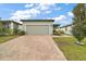 Single-story home with gray siding, paver driveway, and landscaped lawn at 29360 Caspian St, Leesburg, FL 34748