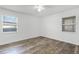 Bright bedroom with wood-look floors and two windows at 2941 Tangerine Ct, Leesburg, FL 34748