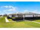 Front view of a house with well-manicured lawn and a screened-in porch at 2941 Tangerine Ct, Leesburg, FL 34748