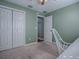 Light green bedroom with double doors and carpet at 307 Batesburg Way, The Villages, FL 32162