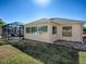 Tan house exterior with screened patio and lawn at 307 Batesburg Way, The Villages, FL 32162