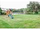 Spacious grassy backyard with a playground and lake view at 31 Sand Lake Pl, Eustis, FL 32726