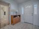 Bright entryway with tiled floor, wooden cabinet, and white door at 32622 Oak Park Dr, Leesburg, FL 34748