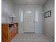 Clean entryway with tiled floor, wooden cabinet, and white door at 32622 Oak Park Dr, Leesburg, FL 34748