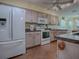 Modern kitchen with white appliances and wood cabinets at 32622 Oak Park Dr, Leesburg, FL 34748