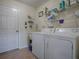 Laundry room with washer, dryer, and ample storage shelving at 32622 Oak Park Dr, Leesburg, FL 34748