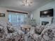 Relaxing living room with floral couches and access to a screened porch at 32622 Oak Park Dr, Leesburg, FL 34748