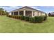 House's back elevation, showcasing a screened porch and well-manicured lawn at 3538 Mistletoe Ct, The Villages, FL 32163