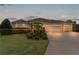 Attractive single-story house exterior at dusk, showcasing garage and landscaping at 3538 Mistletoe Ct, The Villages, FL 32163