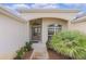 Front entry with arched entryway, double doors, and lush landscaping at 3538 Mistletoe Ct, The Villages, FL 32163