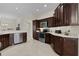 Kitchen with stainless steel appliances, dark wood cabinets, and a corner sink at 3538 Mistletoe Ct, The Villages, FL 32163