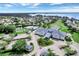 Aerial view of community with clubhouse, tennis courts, and lake at 3546 Tropical Seas Loop, Tavares, FL 32778