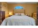 Main bedroom with a comfortable king-size bed and an arched window at 3546 Tropical Seas Loop, Tavares, FL 32778