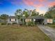 Ranch-style home with carport and mature landscaping at sunset at 3566 Seminole St, Gotha, FL 34734