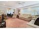 Living room with view into dining area, featuring beige couches and pink carpet at 3566 Seminole St, Gotha, FL 34734