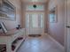 Bright entryway with tiled floor, decorative console table, and elegant front door at 3590 Ithaca Ter, The Villages, FL 32163