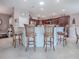 Kitchen island with seating for four and a view into the main living area at 3590 Ithaca Ter, The Villages, FL 32163