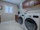 Laundry room with washer, dryer, and built-in cabinets at 3590 Ithaca Ter, The Villages, FL 32163