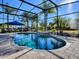 Relaxing screened pool area with patio furniture and a blue umbrella at 3590 Ithaca Ter, The Villages, FL 32163