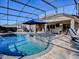 Large screened-in pool with outdoor kitchen and lounge furniture at 3590 Ithaca Ter, The Villages, FL 32163