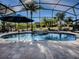 Inviting kidney-shaped pool with a waterfall feature and a screened enclosure at 3590 Ithaca Ter, The Villages, FL 32163