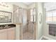 Bathroom featuring a glass enclosed shower with tile surround and neutral cabinets at 37008 Shalimar Dr, Fruitland Park, FL 34731