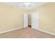 Bedroom with beige carpet, cream walls, white doors, and a ceiling fan at 37008 Shalimar Dr, Fruitland Park, FL 34731