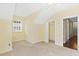 Slanted ceiling bedroom with beige carpet, small closet, window, and white door at 37008 Shalimar Dr, Fruitland Park, FL 34731